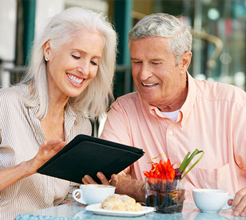 A relaxed senior couple reviewing dental care options together on a tablet