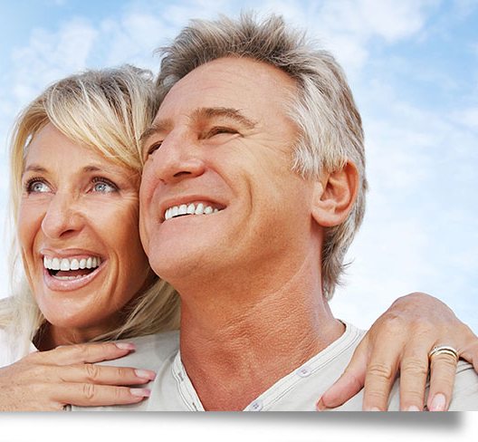 Happy mature couple smiling outdoors after dental treatment