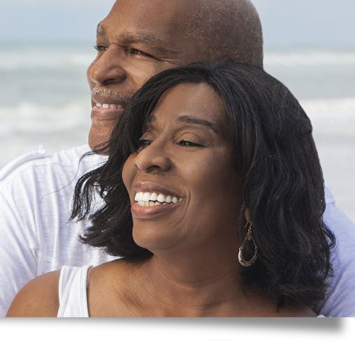 Joyful couple at the beach enjoying their new smiles